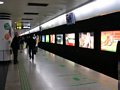 Station 'Peoples Square' - beleuchtete Werbetafeln und Videomonitore üder den Gleisen.